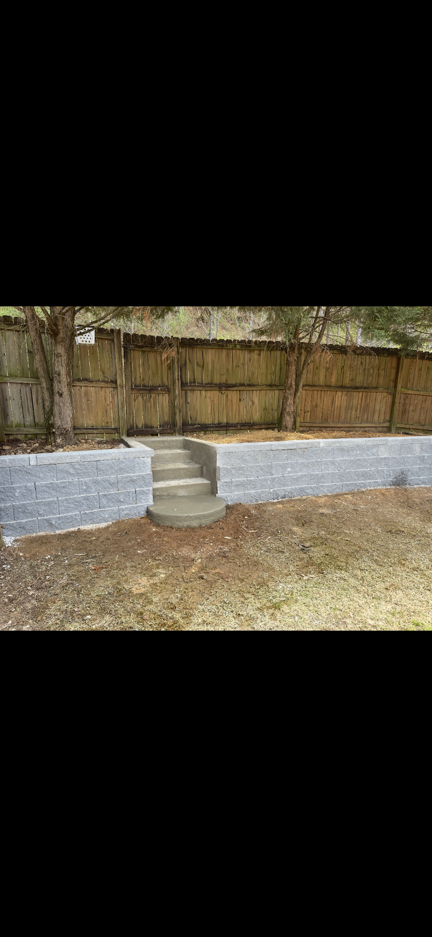 Gray retaining wall with centered concrete steps