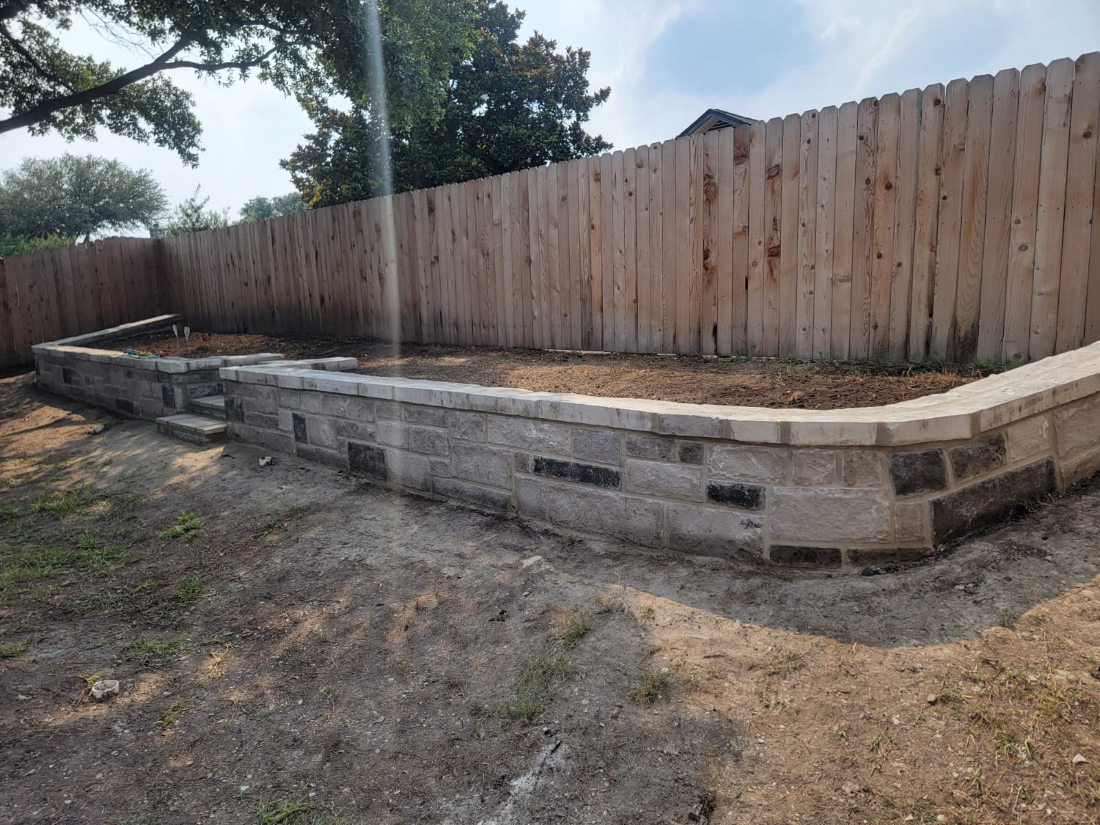 Ashlar retaining wall with wide terrace and built-in steps
