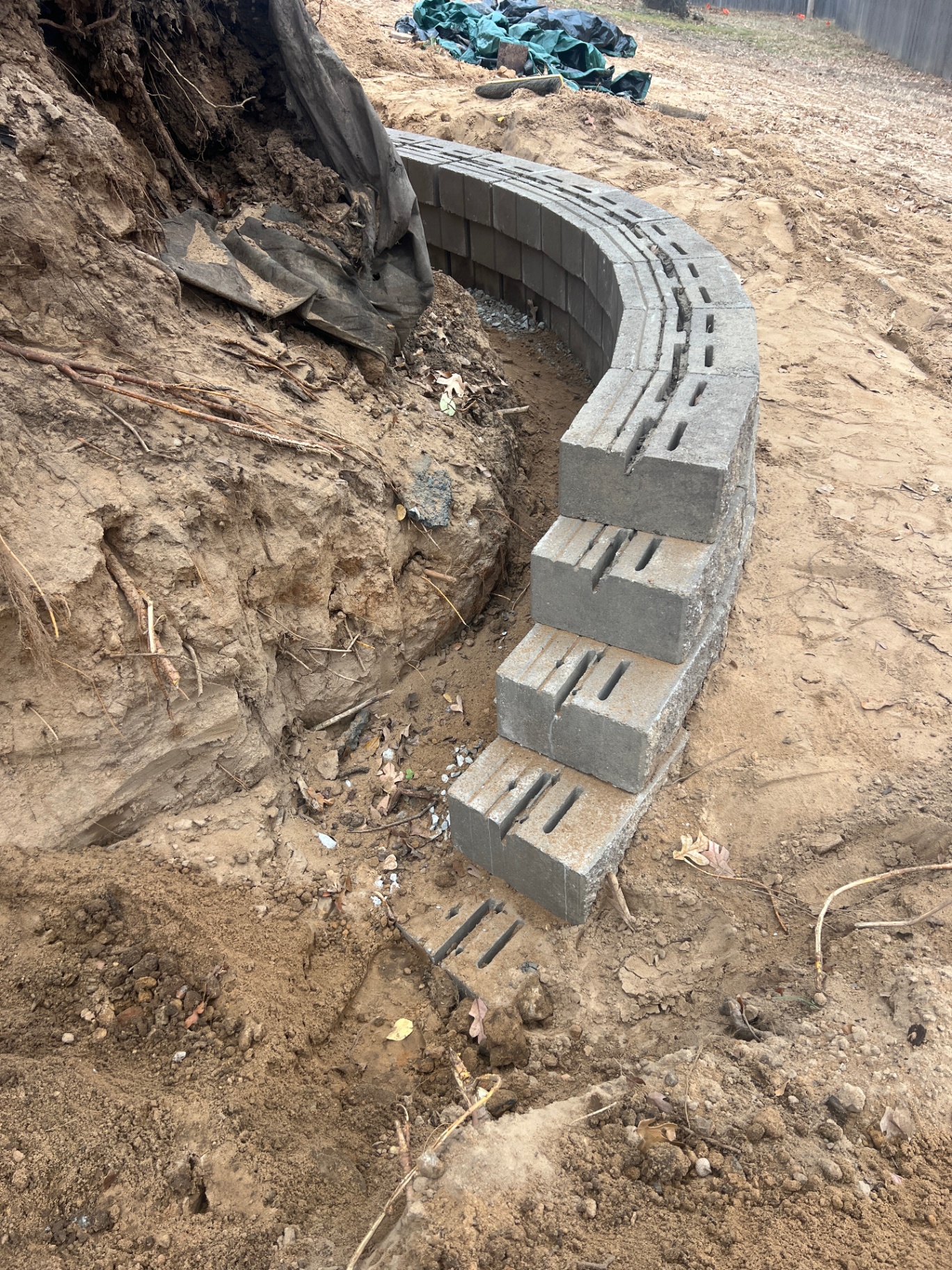 Curved gray retaining wall under construction